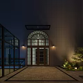 Nighttime Garden Landscape At Building Entrance With Arched Glass Door Wall Lamps And Greenery