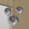 Three moon shaped pendant lights hanging by window with white blinds indoor