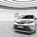 Toyota Silver MPV Car Displayed In Modern Showroom With Logo Background
