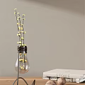 Transparent Light Bulb Shaped Vase With Yellow Flowers And Slender Stems Against Light Gray Wall