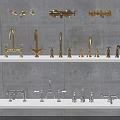 Various Styles of Gold and Silver Faucets Displayed on Gray Wall