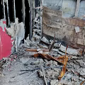 Damaged Building Interior With Collapsed Structures Broken Red Walls Debris And Wooden Fragments