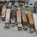 Old Abandoned Trucks Stacked In Dilapidated Ruins With Scattered Rusty Wreckage