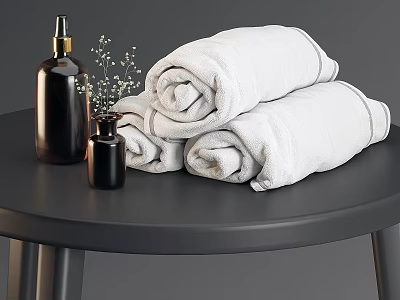White Rolled Bath Towels With Black Soap Dispensers And Small Flower Decor On Black Table 3d model