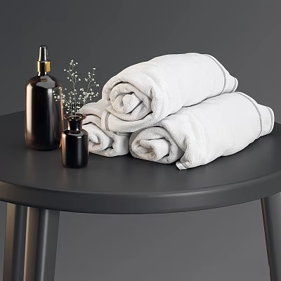 White Rolled Bath Towels With Black Soap Dispensers And Small Flower Decor On Black Table 3d model