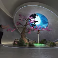 Art Installation Featuring Pink Flowering Tree Rock Formations Circular Window And Illuminated Blue Sky Moon