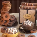 Stacked Chocolate Filled Cookies and Foamy Hot Chocolate Topped with Marshmallows and Decorative Gift Box