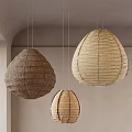 Three Teardrop Shaped Natural Woven Rattan Pendant Lights Hanging In Interior Space