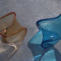 Transparent Colorful Chairs With Streamlined Modern Design On Gray Floor And Light Reflections