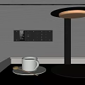 Modern Black Table Lamp With Round Illuminated Shade On Desk Near White Mug