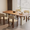 Modern Wooden Dining Table With Four Light Colored Chairs Fruit Bowl And Green Plant