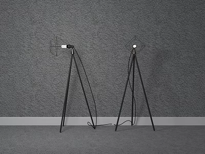 Two Black Tripod Floor Lamps Placed Against Gray Wall With Gray Floor And White Baseboard 3d model