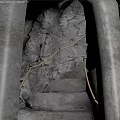 Dimly Lit Cavernous Basement Featuring Stone Stairs Rock Walls And Rope Railings