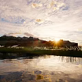 Decorative Outdoor Lights Illuminating Nighttime Grass Field With Mountain Backdrop And Water Reflection