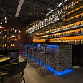 Contemporary Bar Interior With Brick Wall Bar Counter Stools And Illuminated Alcohol Bottle Shelves