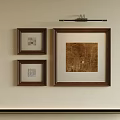 Framed Abstract Painting On Beige Wall With Smaller Artworks And Overhead Spotlight
