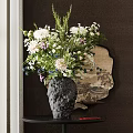 Black Textured Vase With White Purple Flowers On Dark Table Near Round Decorative Mirror