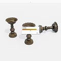 Three Bronze Candlesticks Displayed On White Background With Two Standing And One Overturned