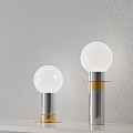 Two Modern Table Lamps With White Globe Shades Silver Bases And Gold Accents On Gray Textured Wall