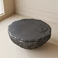 Round Dark Coffee Table With Branch Like Carvings In Light Colored Room With Window