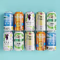 Assorted Canned Drinks With Various Flavors And Brands On Light Blue Background