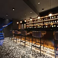 Modern Bar Interior Design With Leather Bar Stools Hanging Lights And Patterned Floor