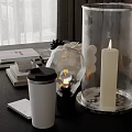 Modern Inflatable Decorative Piece With Transparent Cylinder And Lit Candle On Table