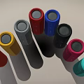 Vibrant Cylindrical Speakers with Multiple Colors Arranged in Arc and Brand Logo