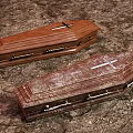New And Aged Wooden Coffins On Dirt Ground With Crosses Metal Handles