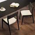 Black Frame Dining Chairs With White Cushion On Wooden Floor Featuring Open Book And Coffee