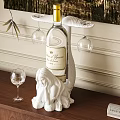 Elegant Wine Bottle And Glasses On White Female Sculpture Base With Wooden Table And Wall Decor