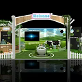 Welcome Themed Exhibition Booth With Green Background Cow And White Picket Fence