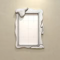 Blue Frame Mirror With Melted Cream Effect Reflecting Bed Pillows And Quilt On Beige Wall