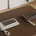 Two Light And Dark Gray Landline Telephones On Wooden Table With White Curly Cords