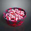 Red and white striped candy arranged in red and black woven basket