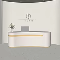 Curved Light Colored Store Front Desk With Laptop Green Plant And Logo On Beige Wall