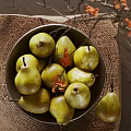 Ceramic Bowl Filled With Yellow Green Pears Featuring Branches And Red Flowers On Woven Mat