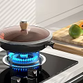 Non-stick Pan With Wooden Handle And Transparent Lid On Gas Stove With Blue Flame