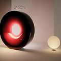 Modern Art Installation With Large Black Circular Design Red Glowing Crescent And Small White Sphere
