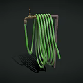 Brass Faucet with Green Coiled Hose on Dark Background and Shadow Detail