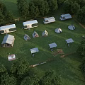 Open Scenic Garden Landscape With Caravans Tents Tables And Lush Surrounding Trees