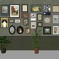 Wall Decor Featuring Various Framed Artworks And Green Plants On Gray Wall