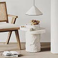 Textured White Stone Side Table with Rattan Chair Bowl of Nuts and Table Lamp