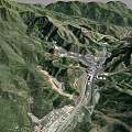 Scenic Aerial View of Green Mountain Valley With Roads and Buildings