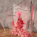 Floral Installation With Transparent Curved Structures And Pink Flowers On Wooden Floor