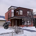 Detached Villa With Red Brick Dark Wooden Exterior Large Windows Snowy Landscape And Trees