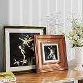 Decorative Framed Artworks with White Vase and Coffee Table Book on Wooden Shelf
