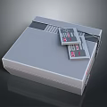 Vintage Gray Entertainment Device With Classic Game Cartridges On Top Surface
