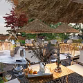 Garden Landscape Design With Thatched Roof Umbrellas Outdoor Seating And Natural Plants