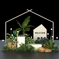 Welcome House Model and Logo in Wooden Frame with Green Plants and Woven Baskets